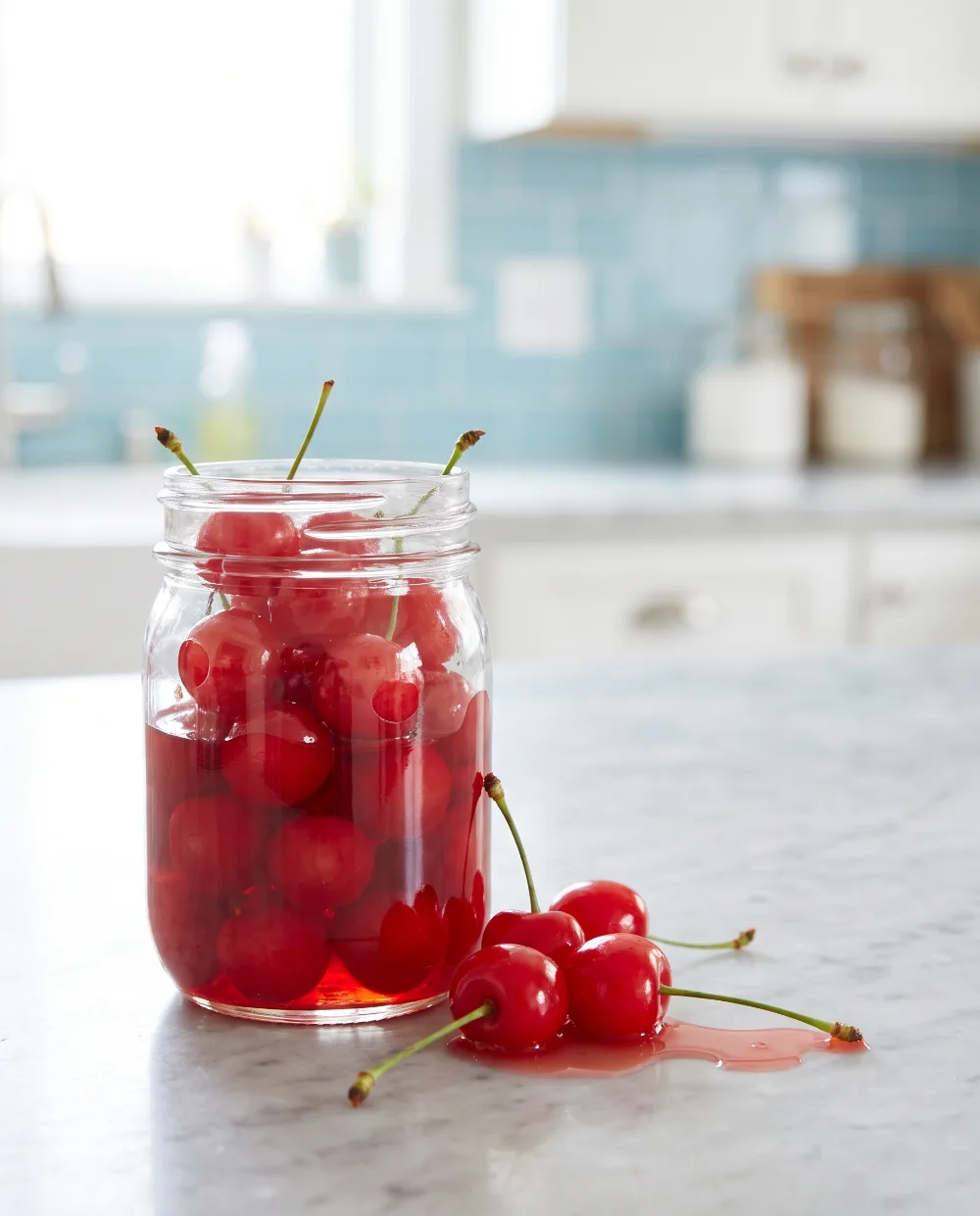 Frasco de cherries en almíbar con cerezas sobre la encimera
